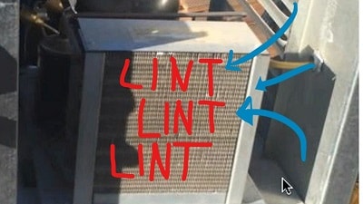 Lint has completely blocked this condenser, causing an immediate need for a cooling unit repair.